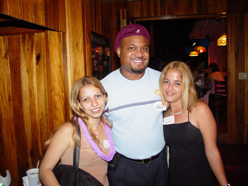 A man posing with two beautiful women.